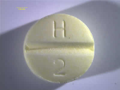 Back photo of yellow Haloperidol with “H 2” imprinted on the tablet. 