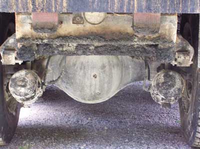 Photo 3: Picture of brakes and pneumatic lines at rear of truck. Truck bed is flat.