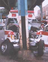 Ambulance after collision with elevated train track support.