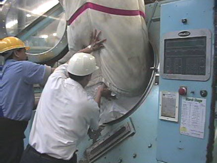 Exhibit #7. View of the laundry sling being unloaded into the industrial washing machine.