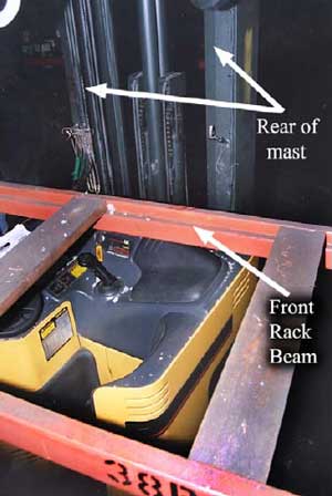 Photo 4 – View from behind the rack beam showing the operator’s work area, machine controls on the console, and the unprotected rear corner of the machine.