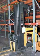Photo 1 – Left-front view of the forklift, positioned as it was found under the empty metal rack beam.