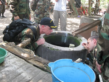 CDR Andrew Smith, an environmental engineer, assesses the quality of a water sample from a water well at the Escuela Santa Isabel in Escuintla in the Republic of Guatemala.  