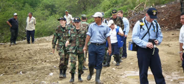 CDR Andrew Smith, an environmental engineer, LT Jull Shugart, an environmental health officer, and LT Elizabeth Leavitt approach a land fill site to analyze its current status.   