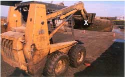 Skid steer loader. Shows approximate location on horizontal bar of scraper attachment which came down and crushed the victim's head.