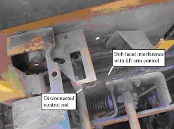 Photo 3 – Control rod for lift arm raising shown disconnected and contacting head of bolt.