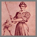 A woman holding a baseball bat with another baseball player in the background.