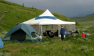 Two tents set up in a grassy field.