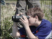A child looking through some binoculars