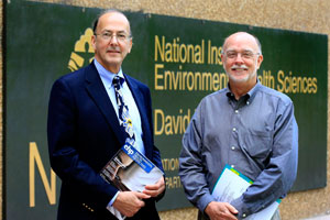 Following his talk, Glass posed with host Bill Suk, right, in front of the building named for one of the pioneers of NIH global health engagement, David Rall.