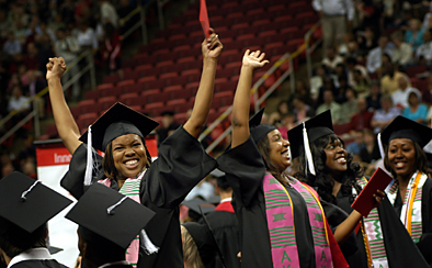 Students celebrate and wave to family and friends as they enter the RBC Center for spring commencement