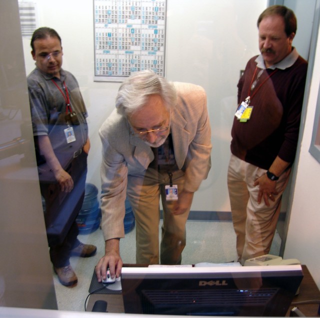 John Immele, Laboratory deputy director for national security, center, starts the Sanitary Effluent Reclamation Facility  operations with the click of a computer mouse on Tuesday. The SERF removes silica from the Laboratory's effluent, which is then pumped to the cooling towers at the Metropolis Computing Center for use in the cooling towers.  The water that contains the naturally occurring silica is pumped into the plant at 105 parts per million and after the treatment has only 0.6 ppm. Immele said that protecting the water resources while enhancing the Lab's mission is invaluable. The facility will save more than 20 million gallons of water a year that is normally pumped from the county acquifer. At right in photo is Orlando L. Archuleta of Radioactive Liquid Waste (NWIS-RLW) while at left is Steve Hanson of NWIS-RLW.