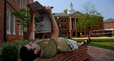 NC State student reads the student newspaper, Technician, while relaxing in the Honors Village.