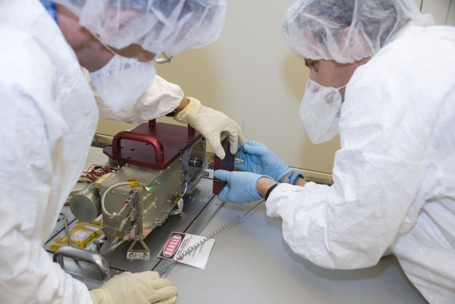 Laboratory scientists Roger Wiens (left) and John Bernardin tweak the ChemCam unit in the laboratory.