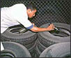   A health worker uses a torch to check for signs of water and mosquito eggs inside tyres in a tyre depot in Cuba