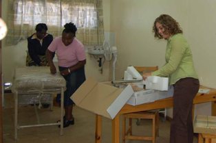 Krista Pfaendler and her Zambian colleagues opening boxes of new lab equipment.