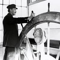 Captain Anthony Meldahl in the pilothouse of the steamboat Queen City