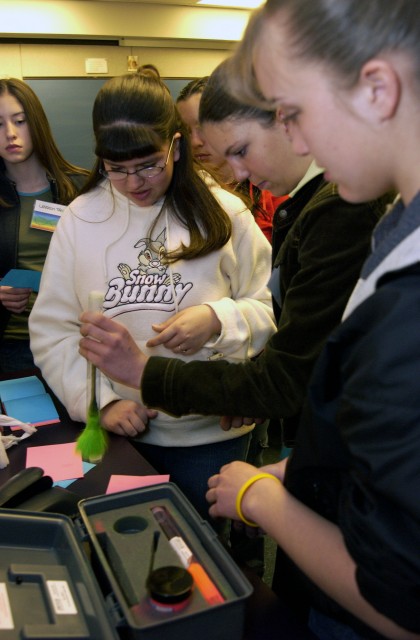 During the “Stamp of Fingerprints” workshop Stephanie Salazar, left, Alyssa Knobeloch, and Janelle Roybal dust for prints.