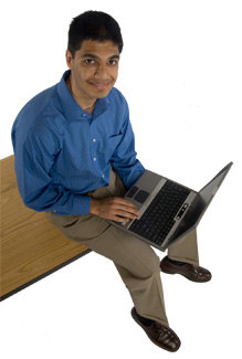 Image of a research assistant sitting at the edge of his desk