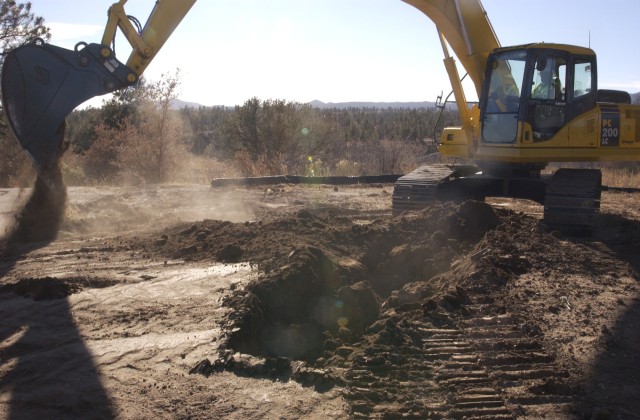 A backhoe lifts the first shovel of dirt for the new Radiological Laboratory Utility Office Thursday at TA-55.