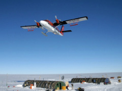 A ski-equipped Twin Otter flies over a field camp in West Antarctica during an aerogeophysical survey of two fast-moving glaciers during the 2004-05 field season.