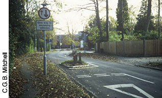 In this photo on a residential road in Hampshire, Britain, a pair of chicanes is used to deflect the traffic stream horizontally. The second pair of chicanes is about 50 meters (164 feet) away. Note the road sign giving priority to traffic leaving the area between the chicanes.