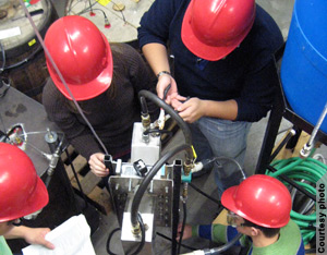 Students work with a piece of equipment (Courtesy University of Arkansas) 
