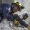 A firefighter searching through rubble (AP Images)