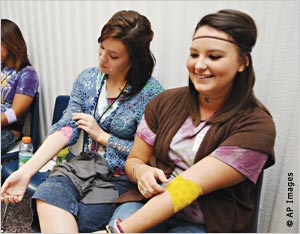Teenage girls with arms extended after giving blood (AP Images)