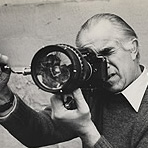 Portrait of David Douglas Duncan looking through a camera lens