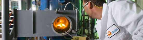 EPA scientist feeding spore-containing building waste into a rotary kiln, as part of an examination of methods to dispose of wastes from facilities contaminated with biological agents.