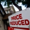 "Price reduced" sign in front of home (AP Images)