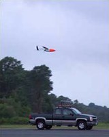 Aerosonde remote controlled aircraft above a pick-up truck it was released from