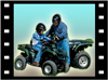 Picture of an adult and a youth on atv's.