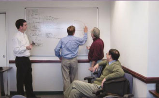 Members of the FHWA Traffic Analysis Team are defining a microsimulation process on a whiteboard. 