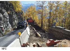 Crews at the site shown here excavated the original retaining wall (at the far right) down to bedrock in preparation for reconstruction. They constructed a temporary retaining wall between the original retaining wall and the Jersey barrier to stabilize the work zone while they were reconstructing the historic retaining wall.