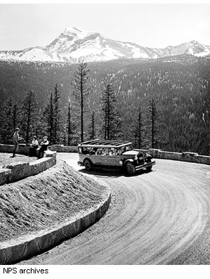 A historic red bus in the late 1920s rounds The Loop, the only switchback constructed on the Going-to-the-Sun Road. The entire fleet of original red "jammers" (so called by the locals because the drivers could be heard jamming the gears on the rugged mountain road) still operates in the park today.