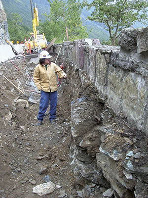 FHWA Resident Engineer Margaret Moen, who worked on the project until early 2006, inspects a construction site where a new and hidden concrete retaining wall was constructed inside the original wall, allowing the historic wall to maintain its original appearance without having to support its former structural load.