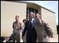 President George W. Bush puts his arm around Chief Warrant Officer David S. Williams as he speaks to the media with Chief Warrant Officer Ronald D. Young Jr., left, and Mrs. Bush after attending Easter church services at the 4th Infantry Division Memorial Chapel at Fort Hood, Sunday, April 20, 2003. Williams and Young are former POW's.  White House photo by Eric Draper