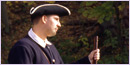 A young man in colonial uniform, with a musket