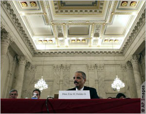 Eric Holder seated at desk, testifying (AP Images)