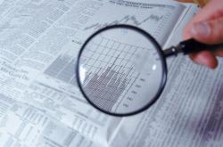 Magnifying glass and financial charts