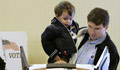 A man holds his young son as he votes (State Dept.)
