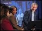 President George W. Bush receives praise from Welfare to Work graduate Ann Briscoe and her husband Alfred at an East Room event at the White House on June 4, 2002.  