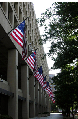 Image of the South Face of the FBI HQ building with Historical American Flags.