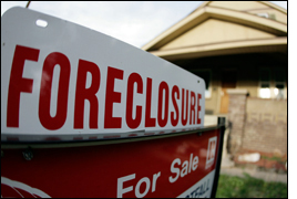 Photograph of a home with a foreclosure sign in front. AP Photo.