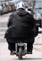 An obese man rides a scooter (AP Images)