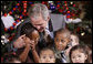 President George W. Bush embraces a group of youngsters Monday, Dec. 8, 2008, as he welcomes children attending the Children's Holiday Reception and Performance at the White House.  White House photo by Eric Draper