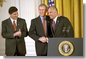 President George W. Bush embraces his nominee for Surgeon General, Dr. Richard Carmona, as Dr. Elias Zerhouni, left, applauds in the East Room Tuesday, March 26. Dr. Zerhouni is nominated to be the Director of the National Institute of Health. White House photo by Tina Hager.