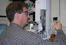 A NIST chemist demonstrates sampling of biodiesel fuel for injection into a gas chromatograph-mass spectrometer, an instrument that separates and identifies the components of a mixture. Click here for larger photo.